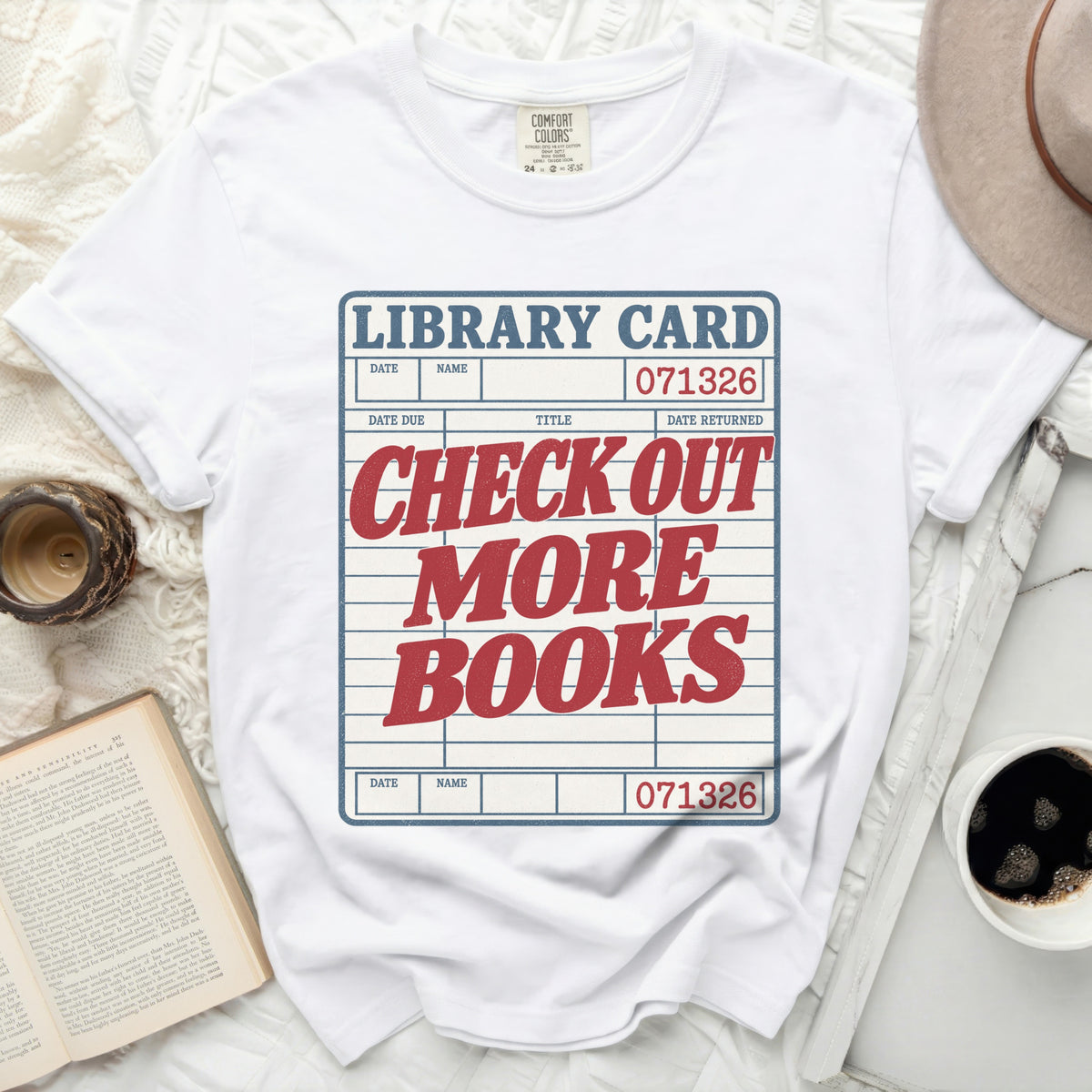 White t-shirt with "Library Card: Check Out More Books" graphic.