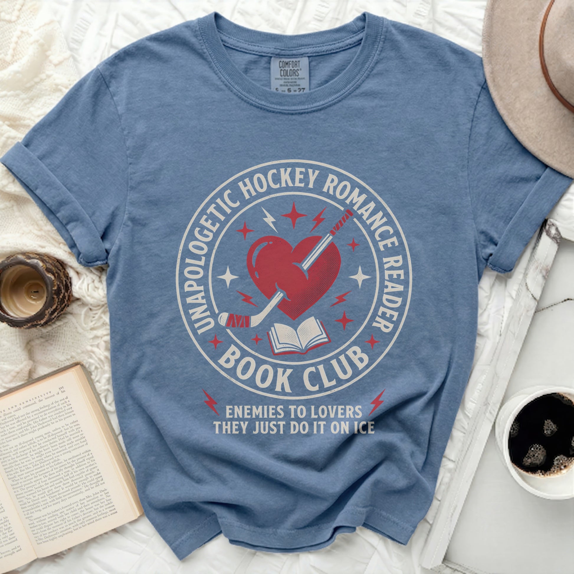 Blue t-shirt with "Unapologetic Hockey Romance Reader" and "Enemies to Lovers" text.