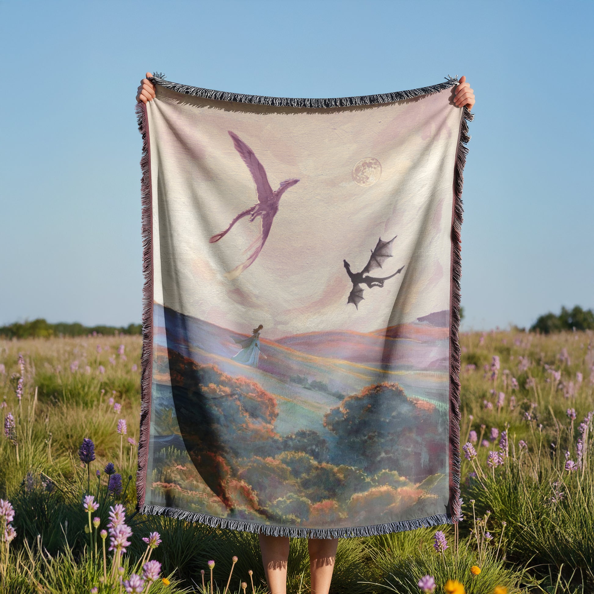 A person is holding a large blanket with a painting of a dragon and a woman in a field of flowers.
