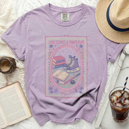 T-shirt with "Love Stories & Power Plays" and romantic tropes graphic.