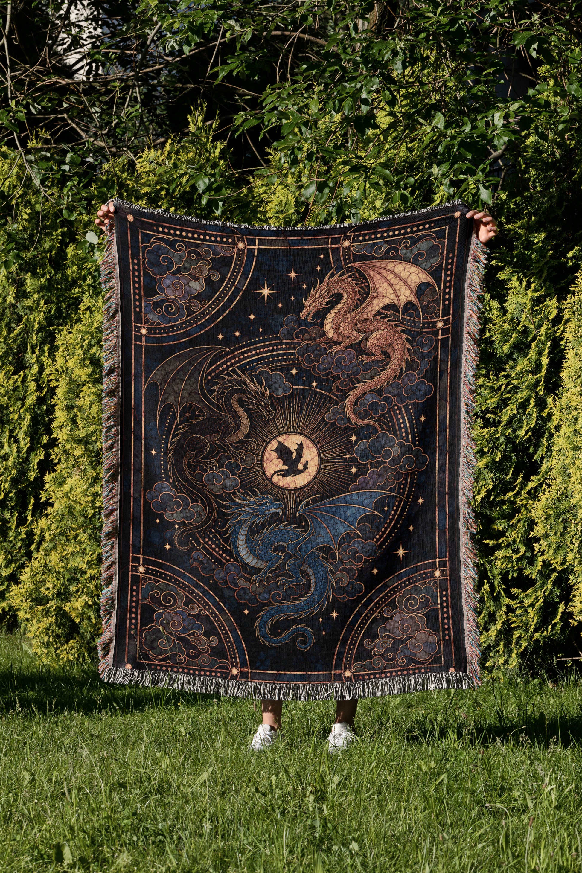A person is holding up a large, intricately designed tapestry featuring a dragon and a moon against a starry night sky background.