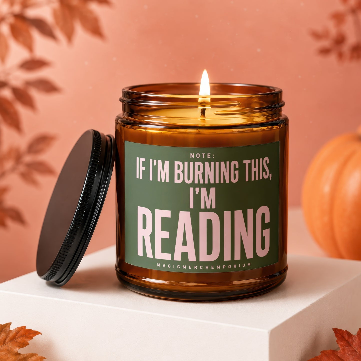 Amber jar candle with lid off, featuring text "Note: If I'm burning this, I'm reading".