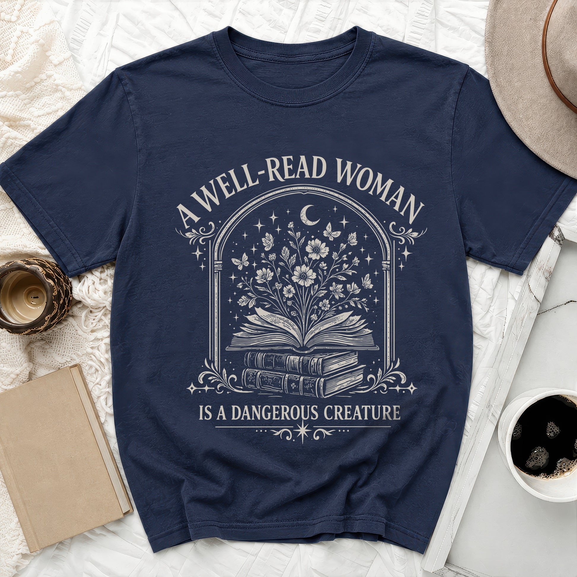 Navy t-shirt with "A Well-Read Woman Is A Dangerous Creature" text and book graphic.