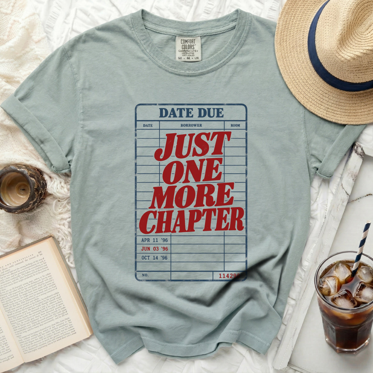 T-shirt with "DATE DUE JUST ONE MORE CHAPTER" printed in red on a library card design.