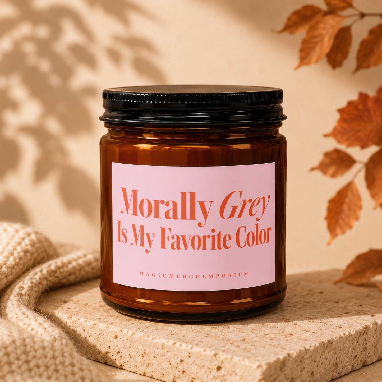 Brown candle in amber jar with pink label saying "Morally Grey Is My Favorite Color".