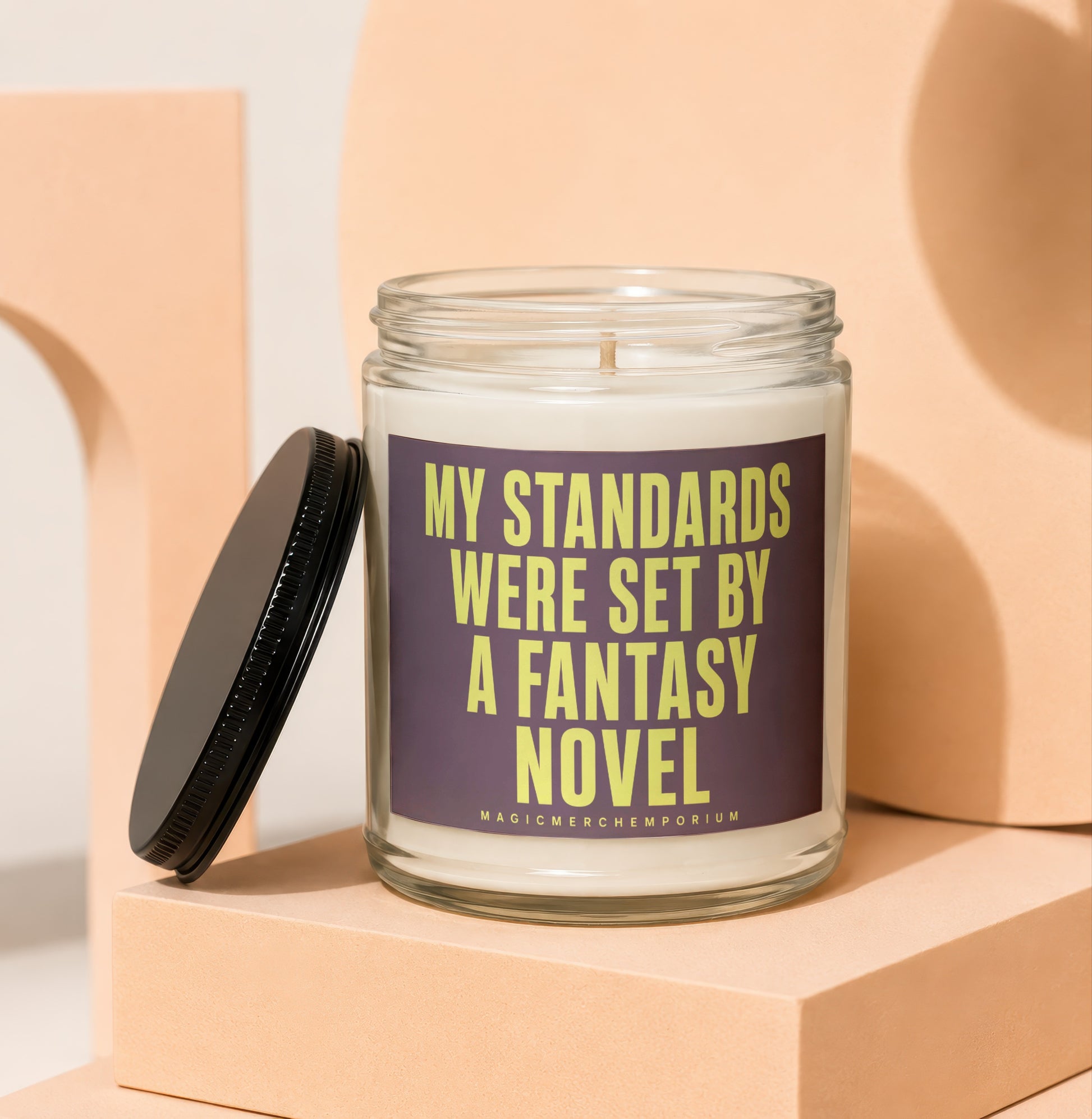 Glass candle with label reading "My standards were set by a fantasy novel".