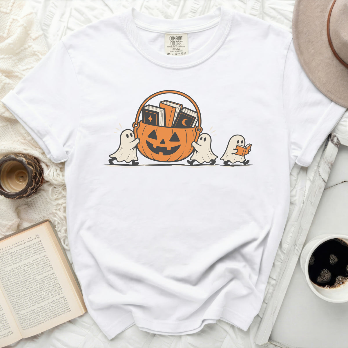 White t-shirt with ghosts carrying a pumpkin basket filled with books.