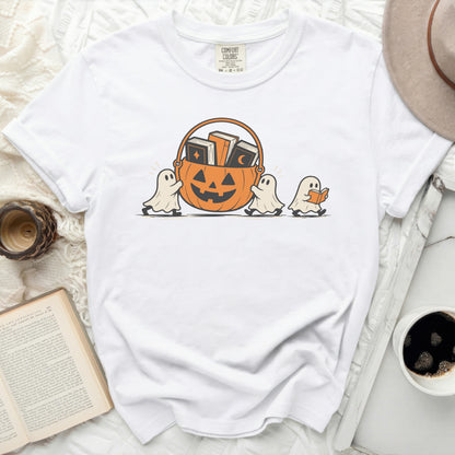 White t-shirt with ghosts carrying a pumpkin basket filled with books.