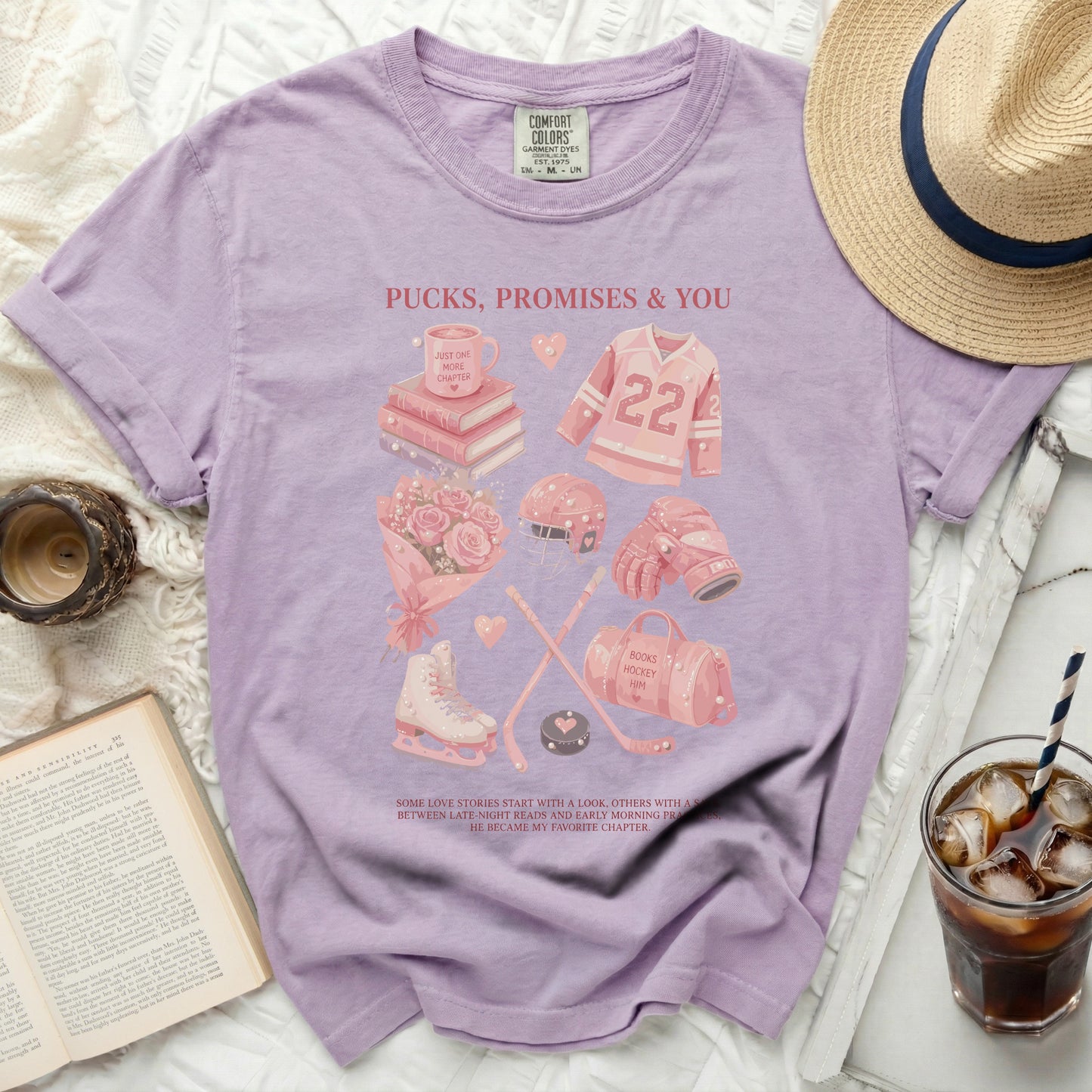 Purple Comfort Colors t-shirt with hockey and book graphics, and text "Pucks, Promises & You".