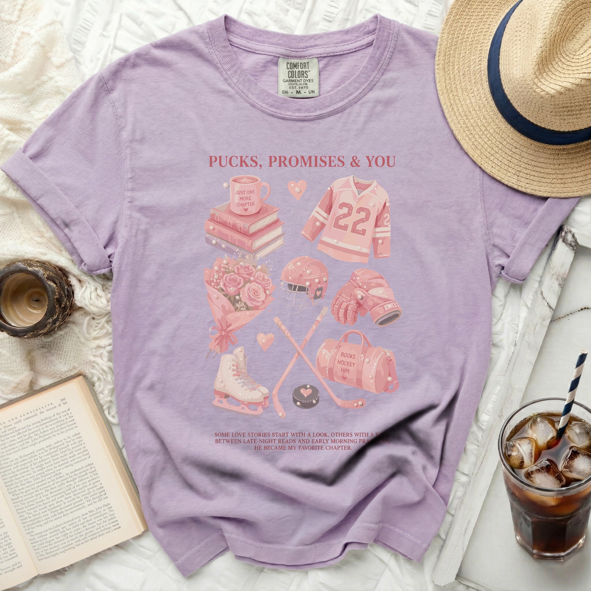 Purple Comfort Colors t-shirt with hockey and book graphics, and text "Pucks, Promises & You".
