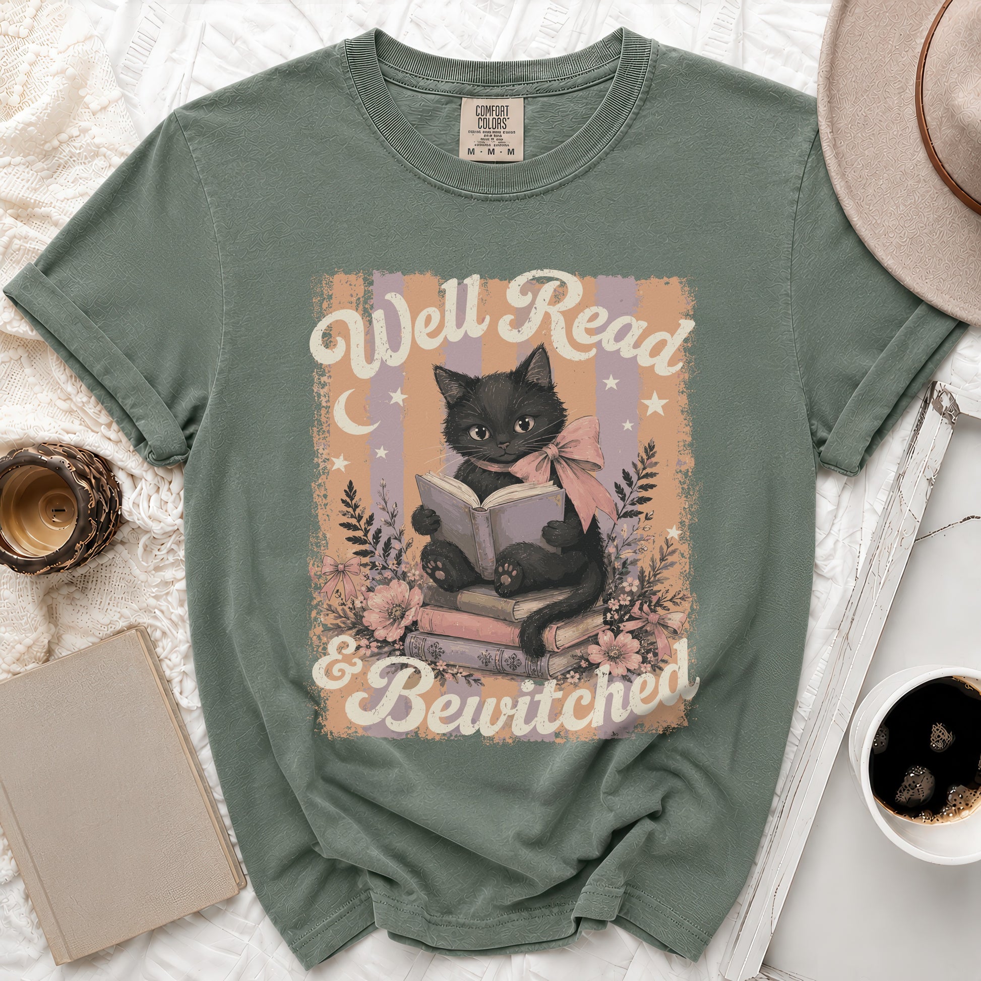 Green t-shirt with black cat reading on books, saying: Well Read & Bewitched.
