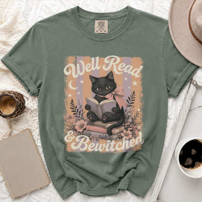 Green t-shirt with black cat reading on books, saying: Well Read & Bewitched.