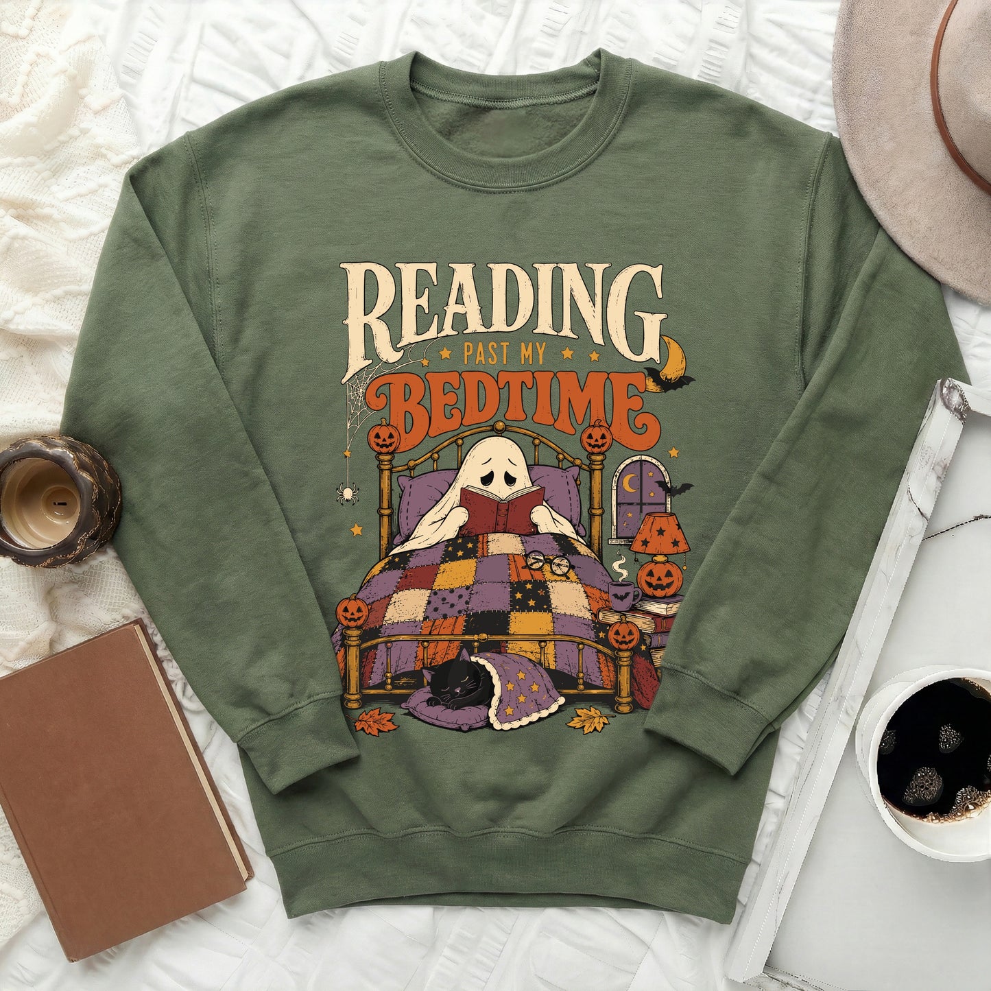 Green sweatshirt with a ghost reading in bed and the text "Reading Past My Bedtime".