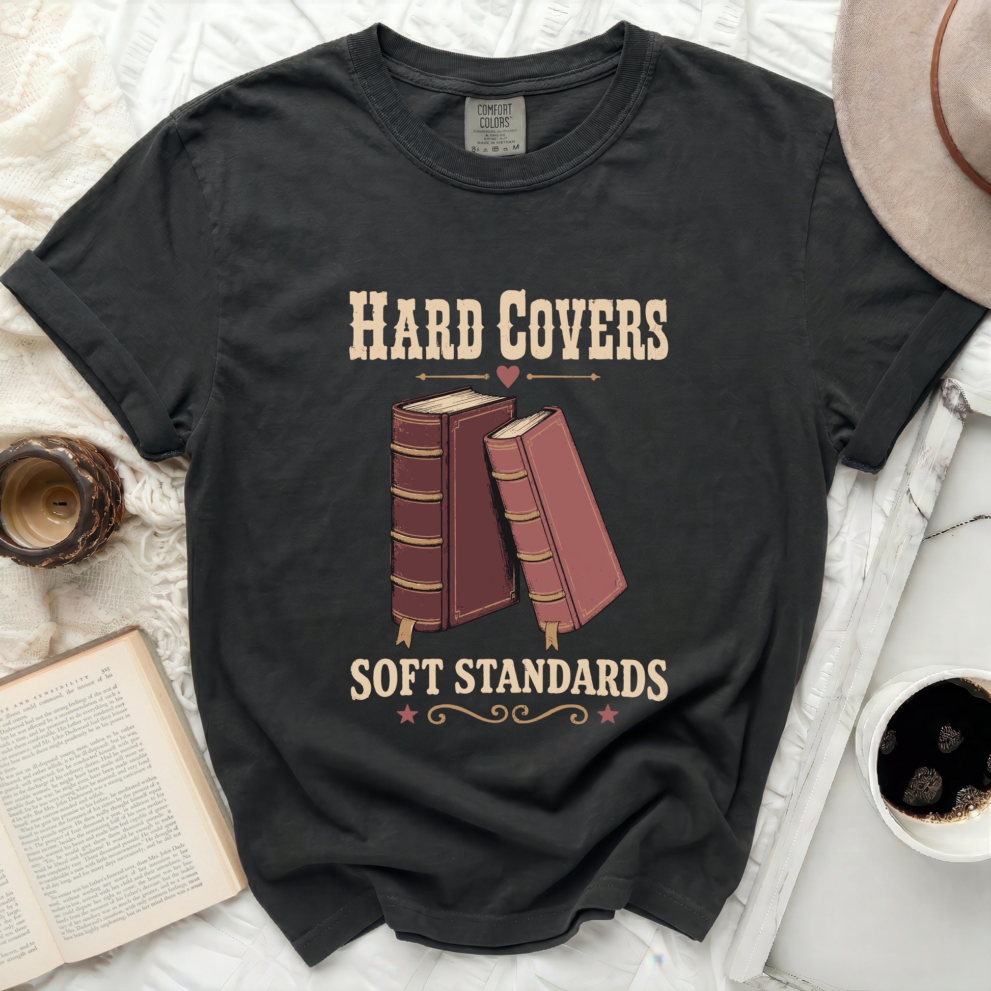 Black t-shirt with "Hard Covers Soft Standards" text and book graphic.