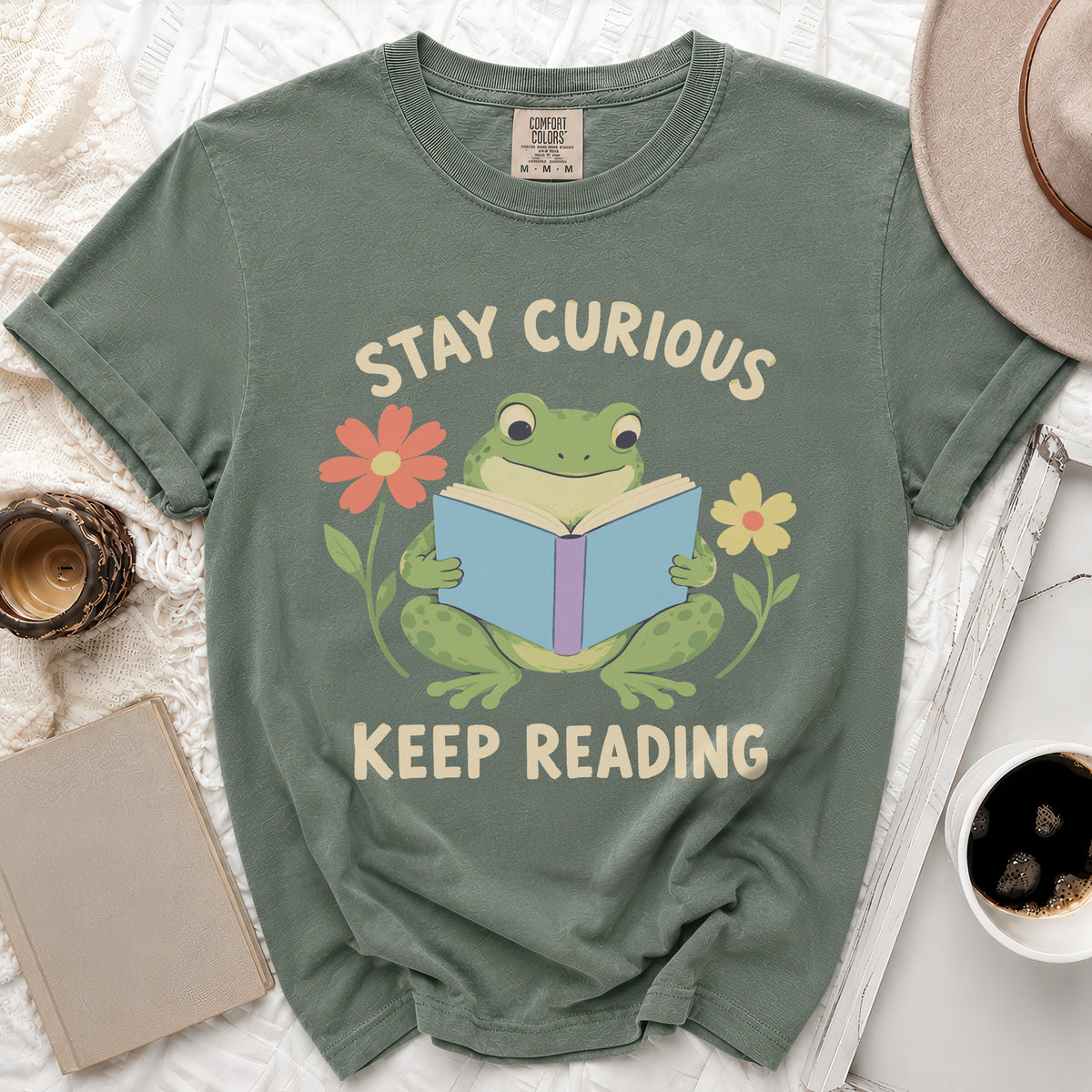 Green t-shirt with frog reading book, "Stay Curious Keep Reading" text.