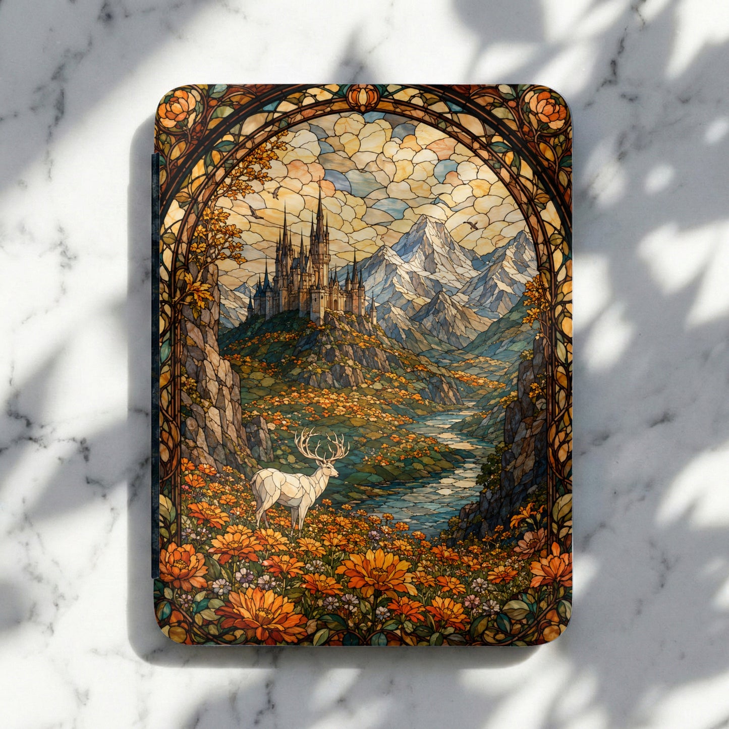 Stained glass art of a white stag in a field of orange flowers with a castle and mountains.