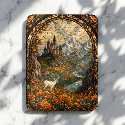 Stained glass art of a white stag in a field of orange flowers with a castle and mountains.