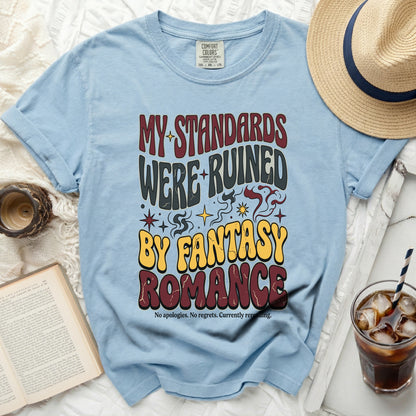 Light blue t-shirt with "MY STANDARDS WERE RUINED BY FANTASY ROMANCE" text.