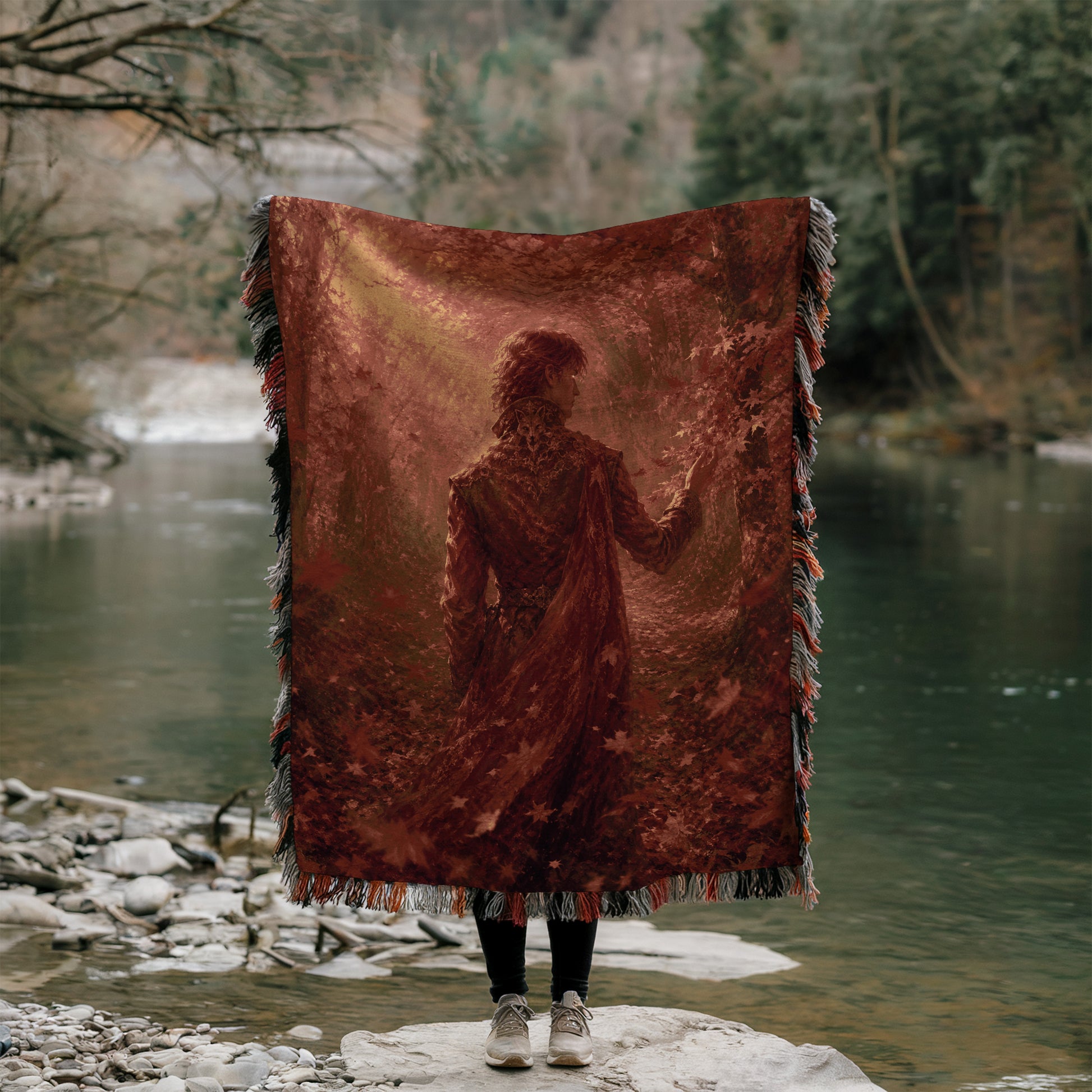 A person stands on a rock, holding a large red blanket with a silhouette of a person on it, partially obscuring their face.