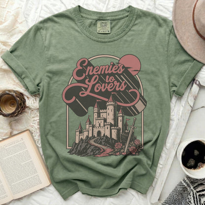 Green t-shirt with "Enemies to Lovers" graphic featuring a castle.
