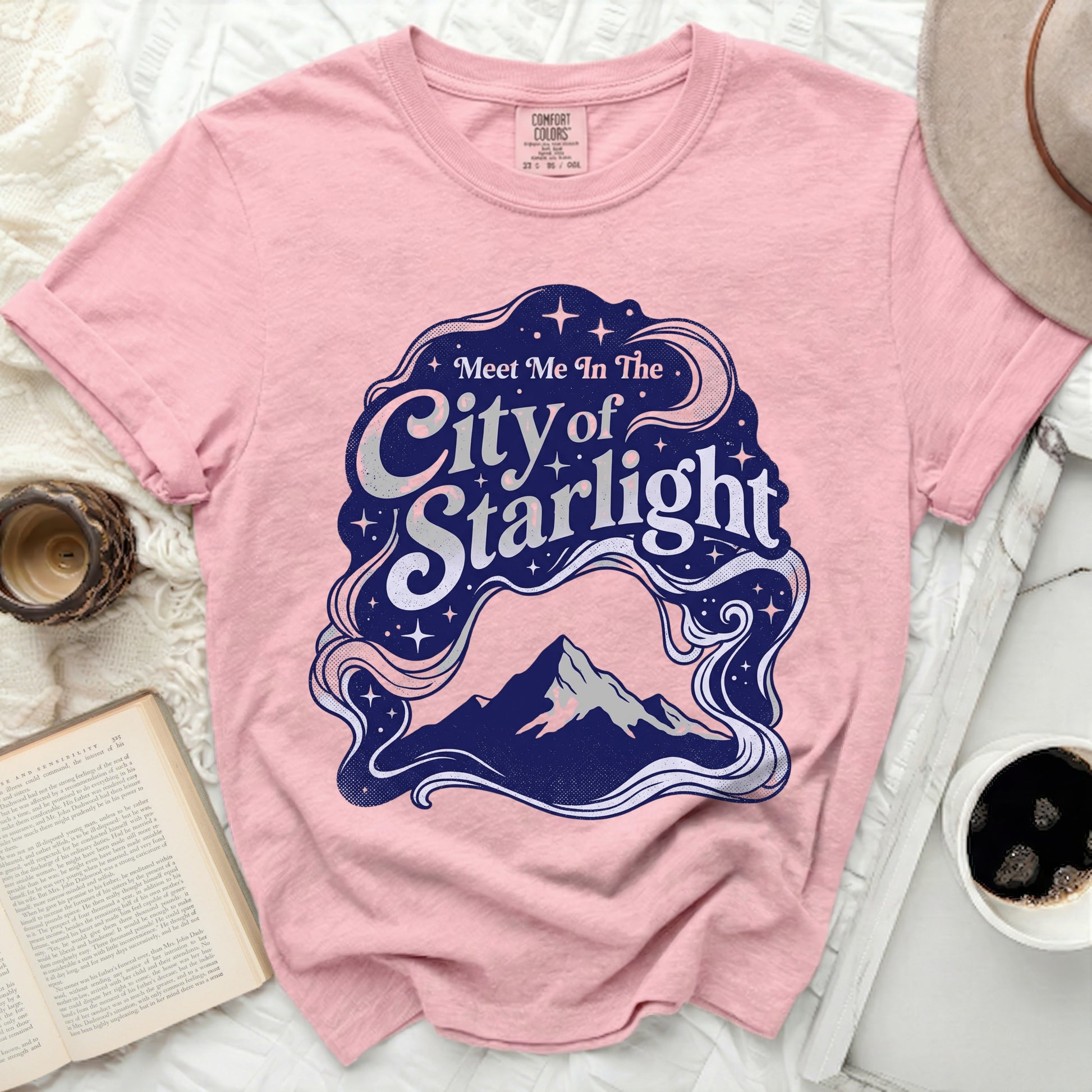 Pink t-shirt with "Meet Me In The City of Starlight" graphic.