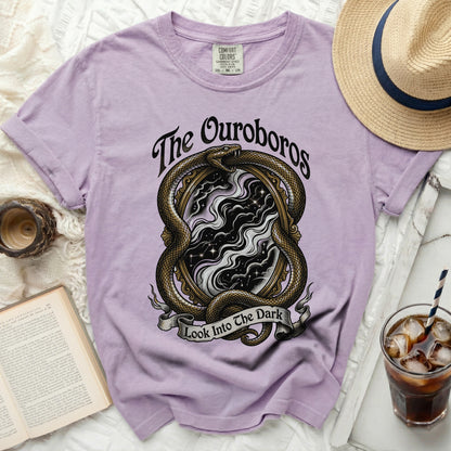 Lavender t-shirt with snake, mirror, and text "The Ouroboros Look Into The Dark".