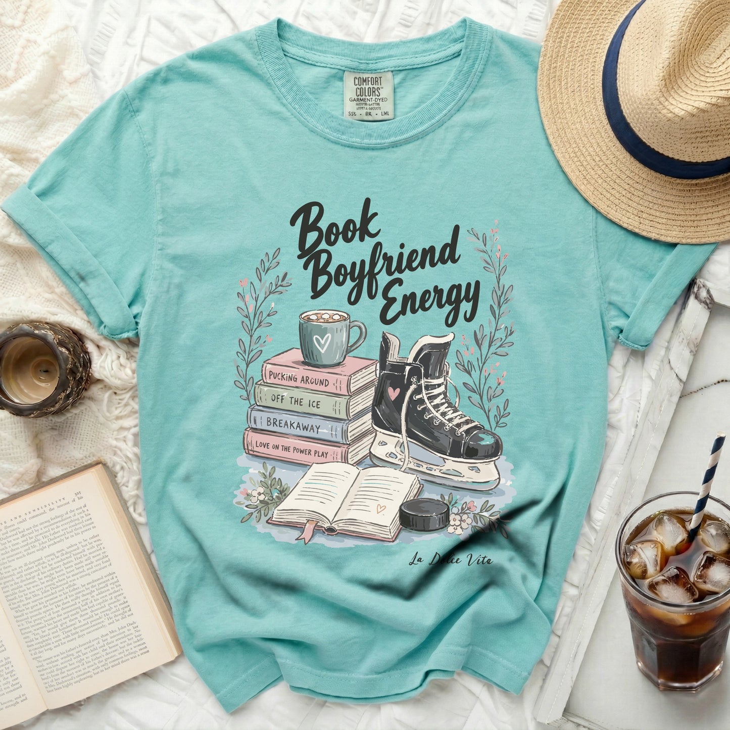 Aqua t-shirt with "Book Boyfriend Energy" graphic and stacked books, ice skate, and mug.