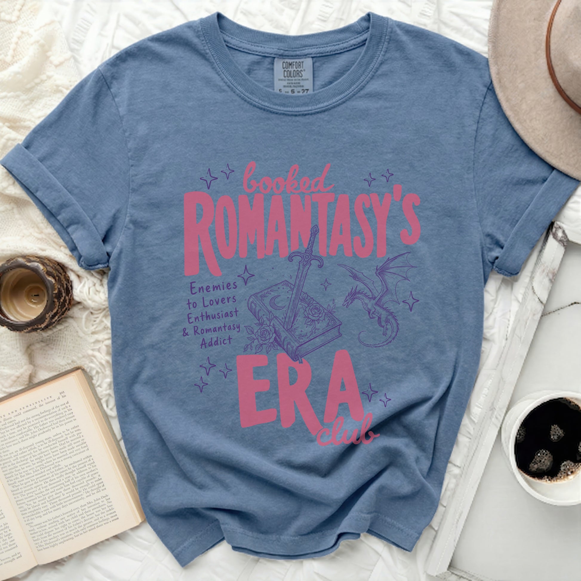 Booked Romantasy's Era club graphic on a blue t-shirt.
