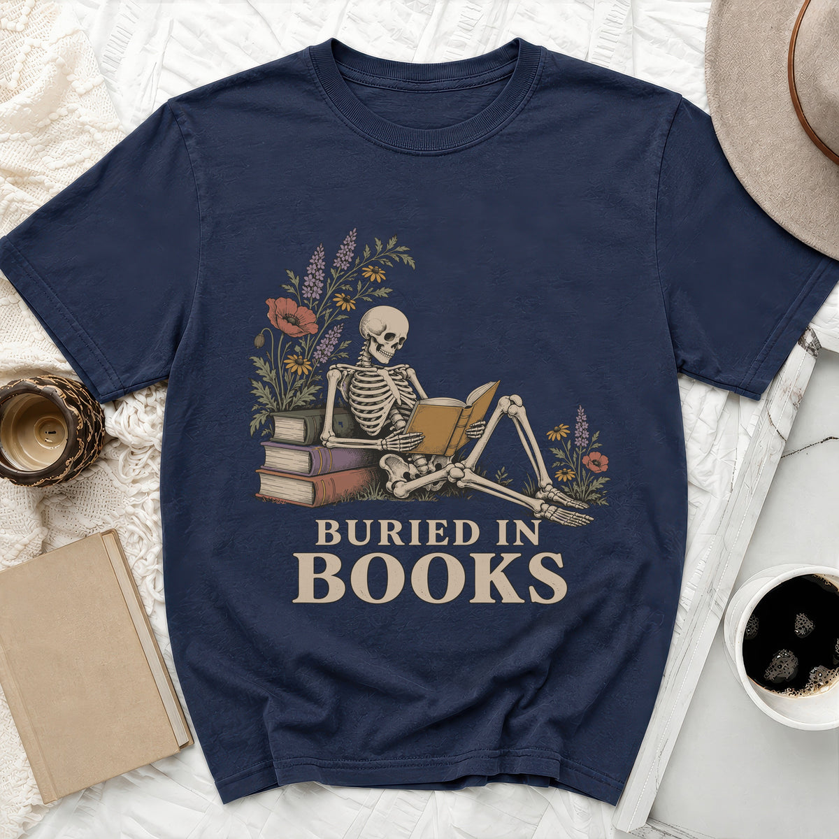 Navy t-shirt with skeleton reading books and the text "Buried In Books".