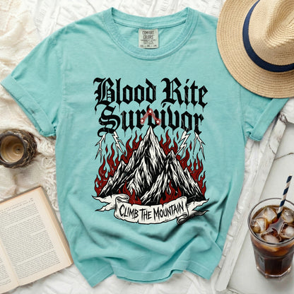 Teal t-shirt with "Blood Rite Survivor Climb The Mountain" graphic.
