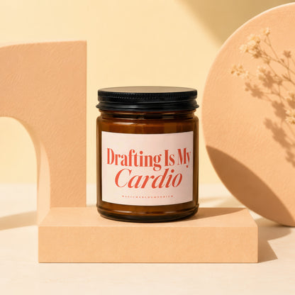 Amber jar candle with black lid, labeled "Drafting Is My Cardio MAGICMERCHEMPORIUM".