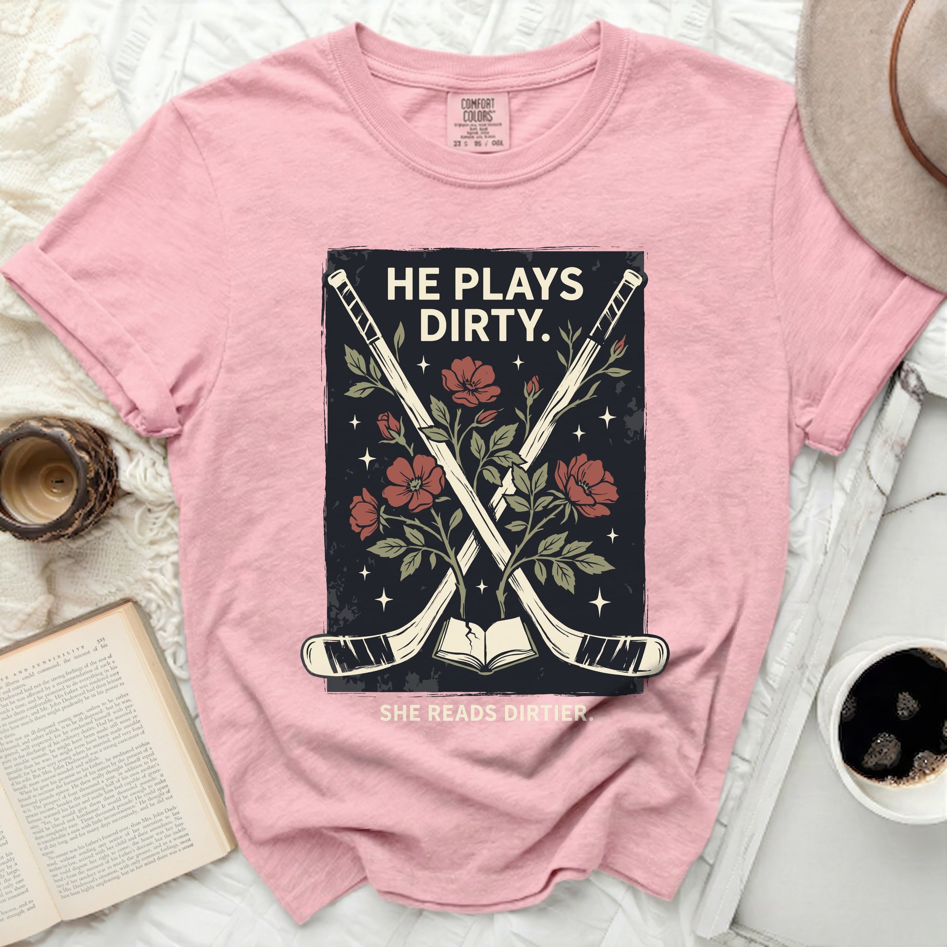 Pink t-shirt with hockey sticks, flowers, and text.