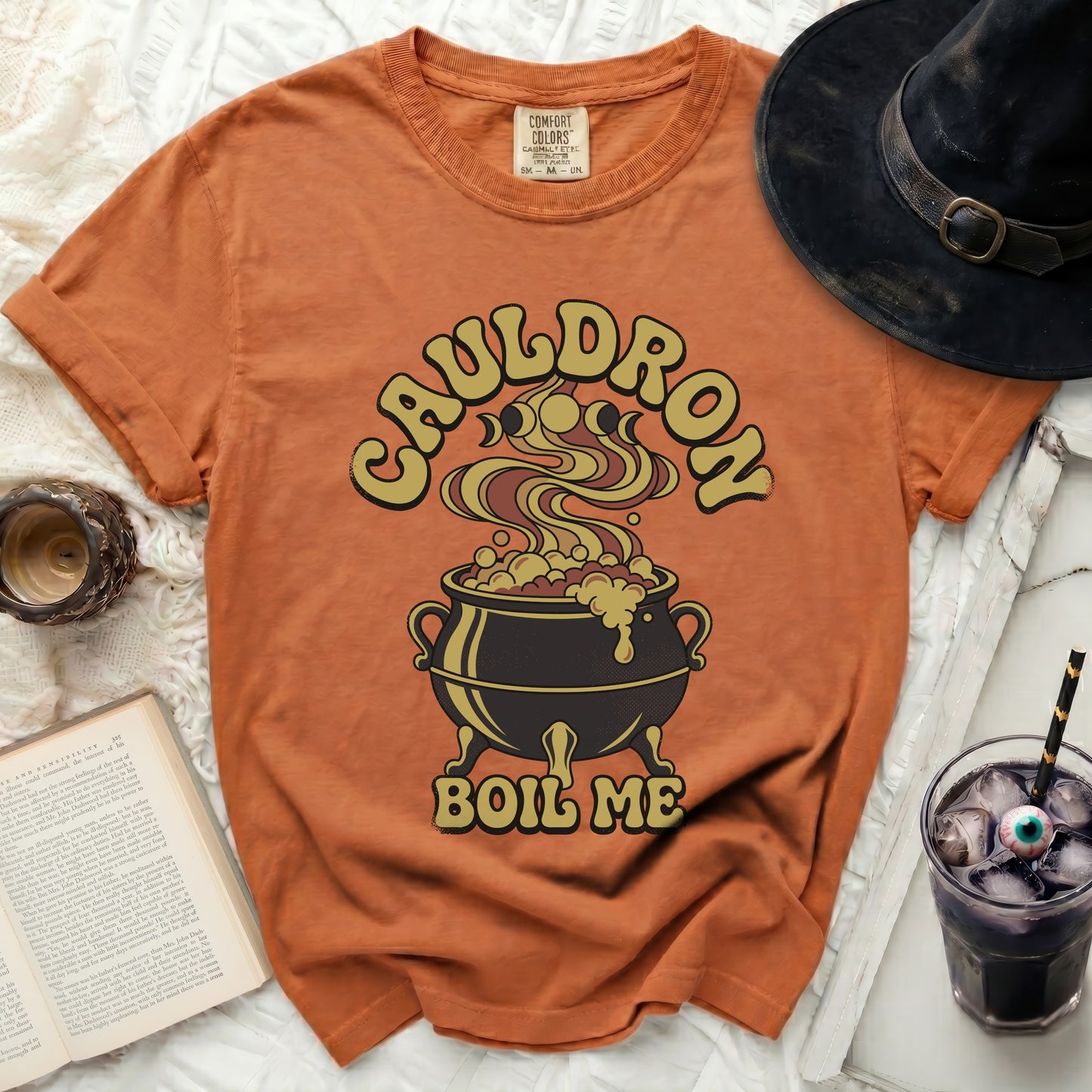 Orange t-shirt with "CAULDRON BOIL ME" text and a bubbling cauldron graphic.