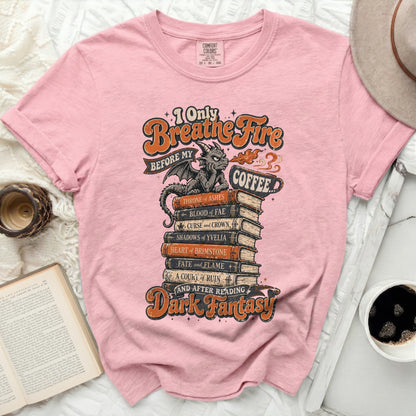 Pink t-shirt with "I Only Breathe Fire Before My Coffee" and dark fantasy book titles.