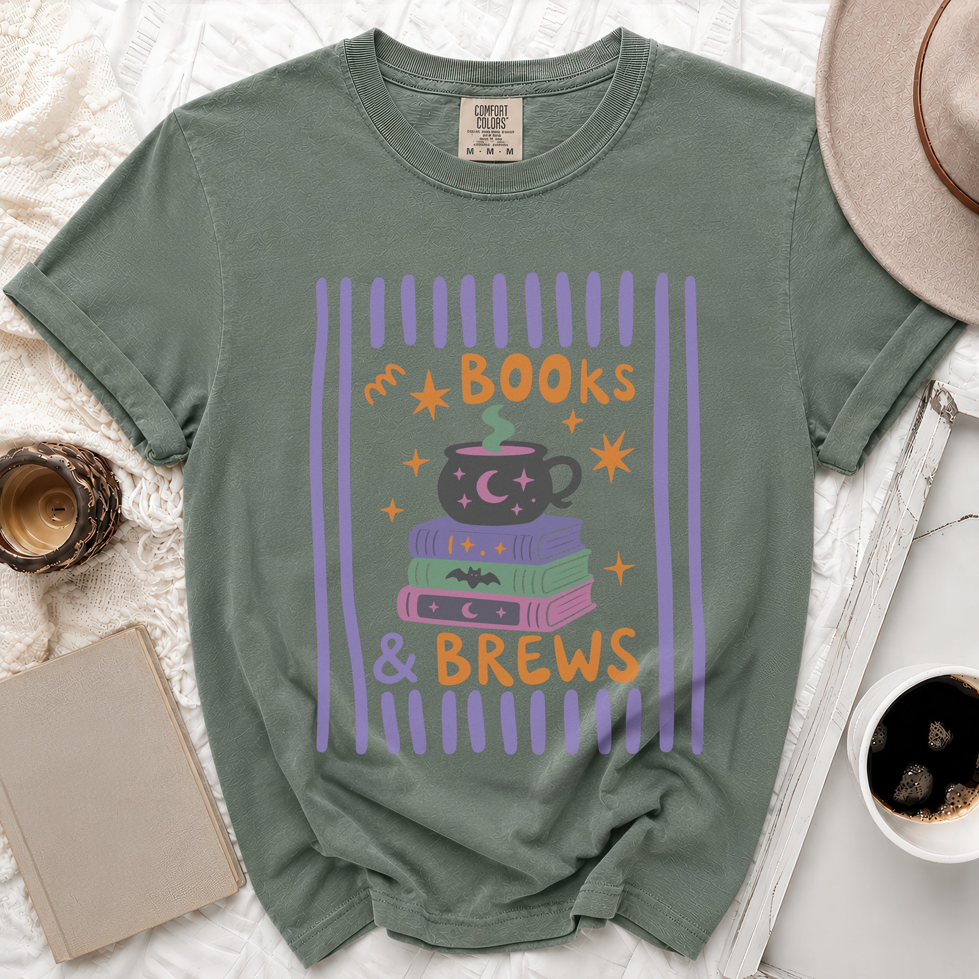 Green t-shirt with "Books & Brews" graphic featuring a cauldron and stacked books.