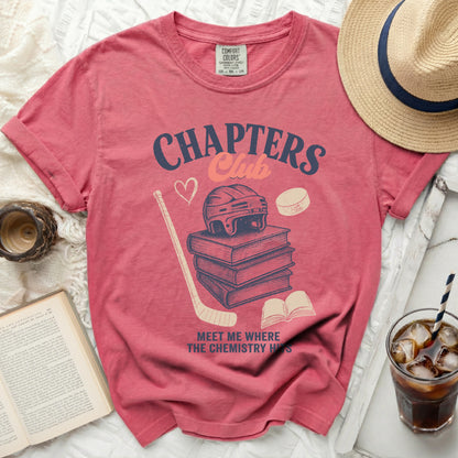 Pink t-shirt with stacked books, hockey puck, helmet, and text.