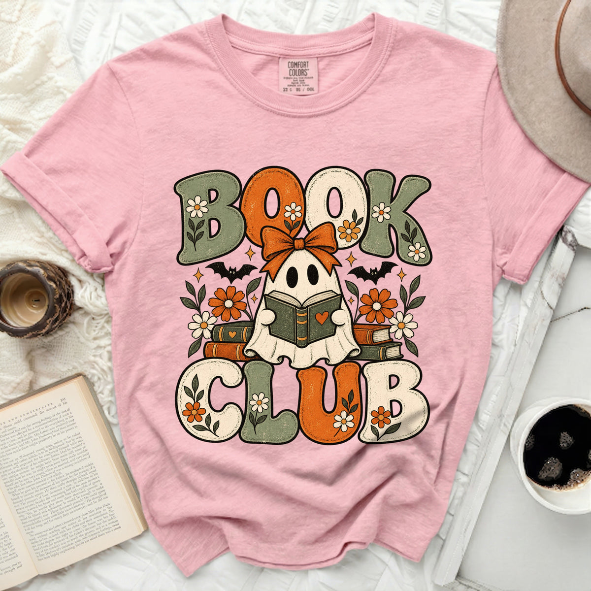Pink t-shirt with "BOOK CLUB" graphic featuring a ghost holding a book and bats.