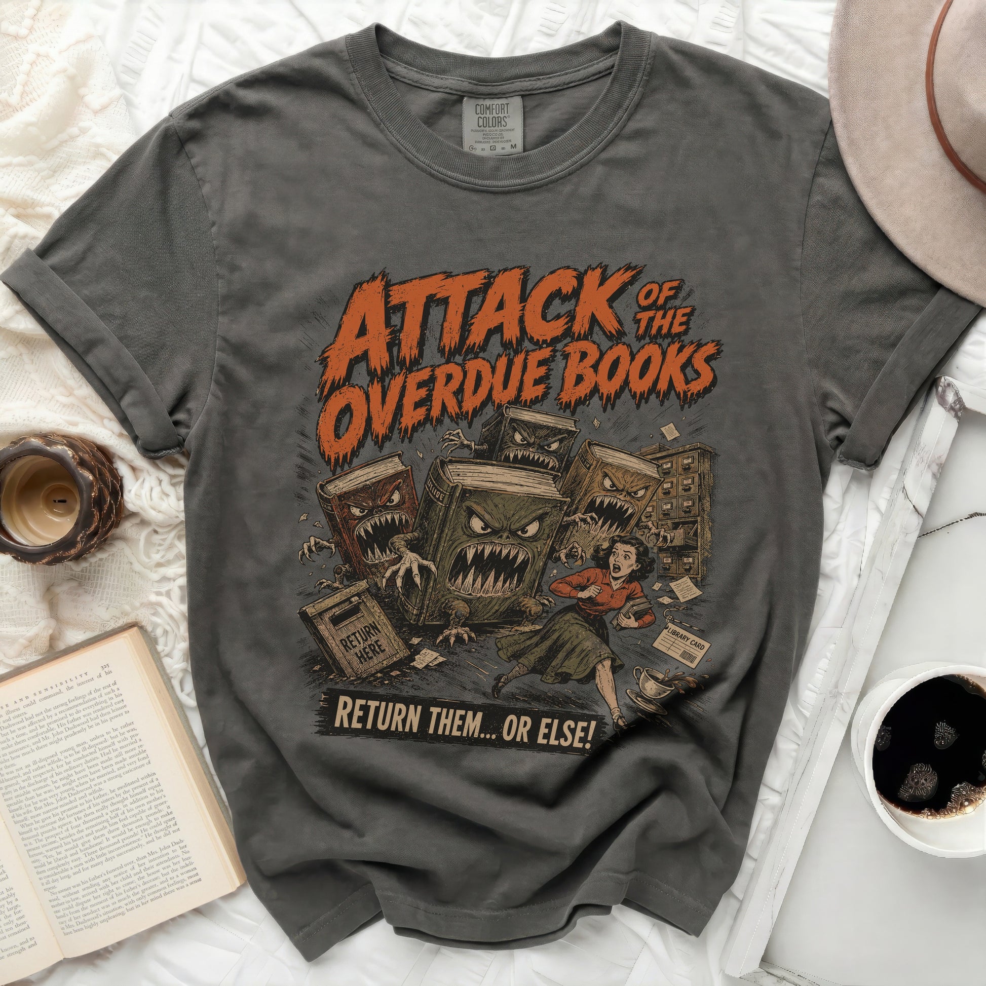 Shirt with "Attack of the Overdue Books" graphic and horror-themed books chasing a woman.