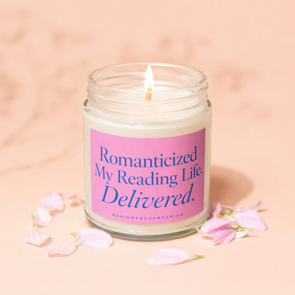 Lit candle in glass jar with pink label reading "Romanticized My Reading Life. Delivered."