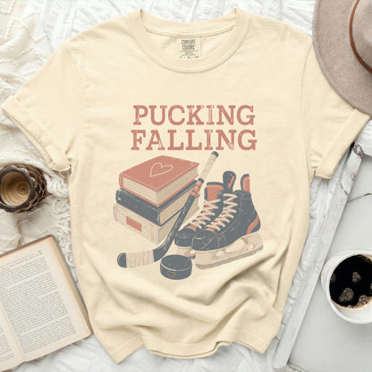 Cream t-shirt with "Pucking Falling" text and hockey gear illustration.