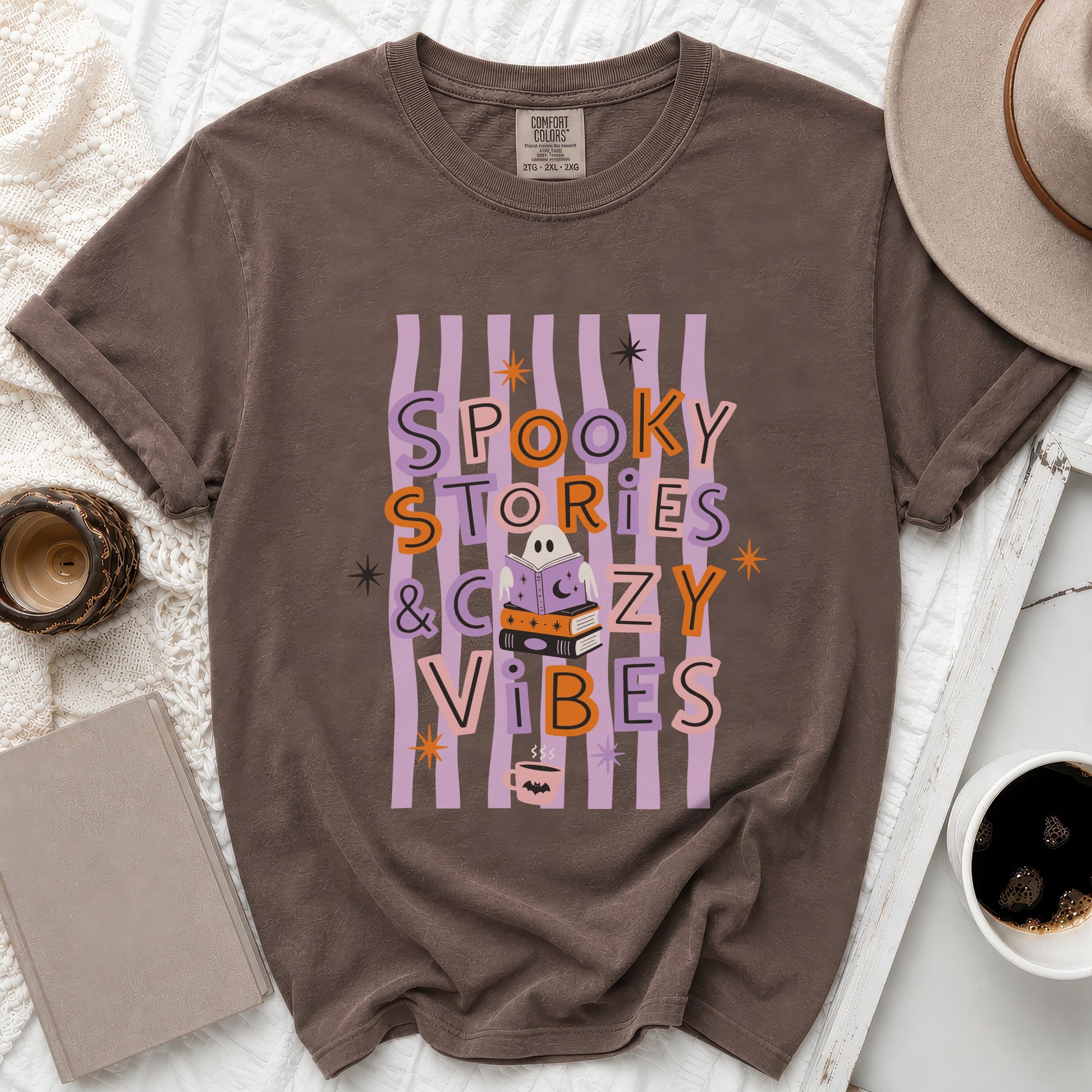 Brown t-shirt with "Spooky Stories & Cozy Vibes" text and Halloween graphics.