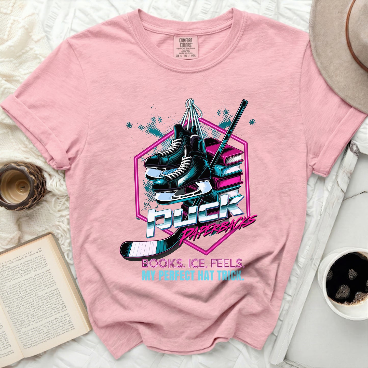 Pink t-shirt with hockey skates, puck, books, and text "Puck Books. Ice. Feels. My Perfect Hat Trick."