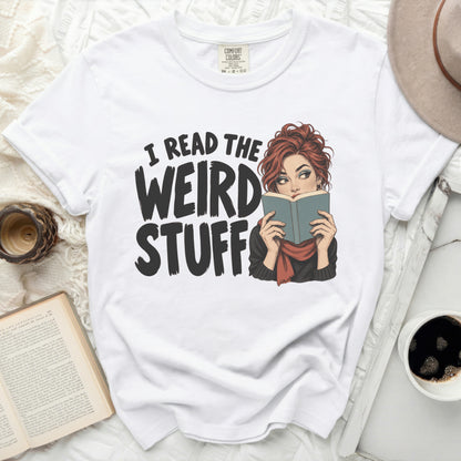 White t-shirt with "I READ THE WEIRD STUFF" text and graphic of woman reading.