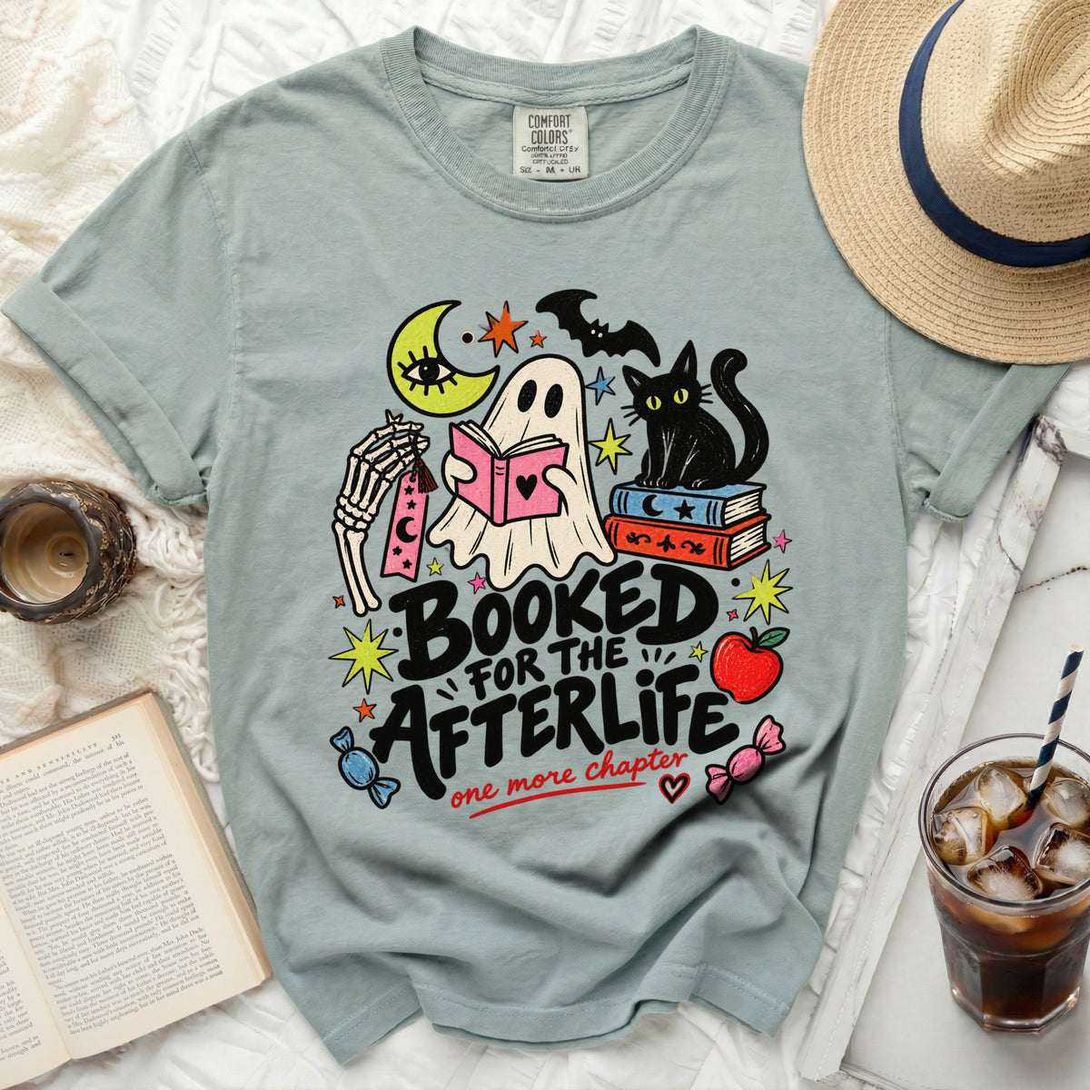Ghost reading book with black cat and moon, text "Booked for the afterlife".