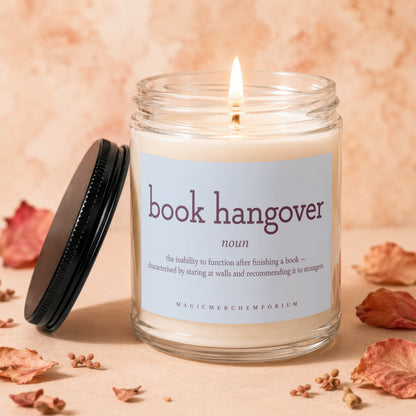 Lit soy candle with "book hangover" definition on label and autumn decor.