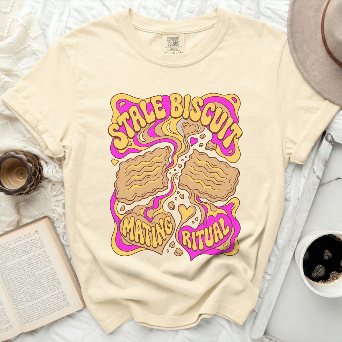 Cream t-shirt with "STALE BISCUIT MATING RITUAL" graphic.