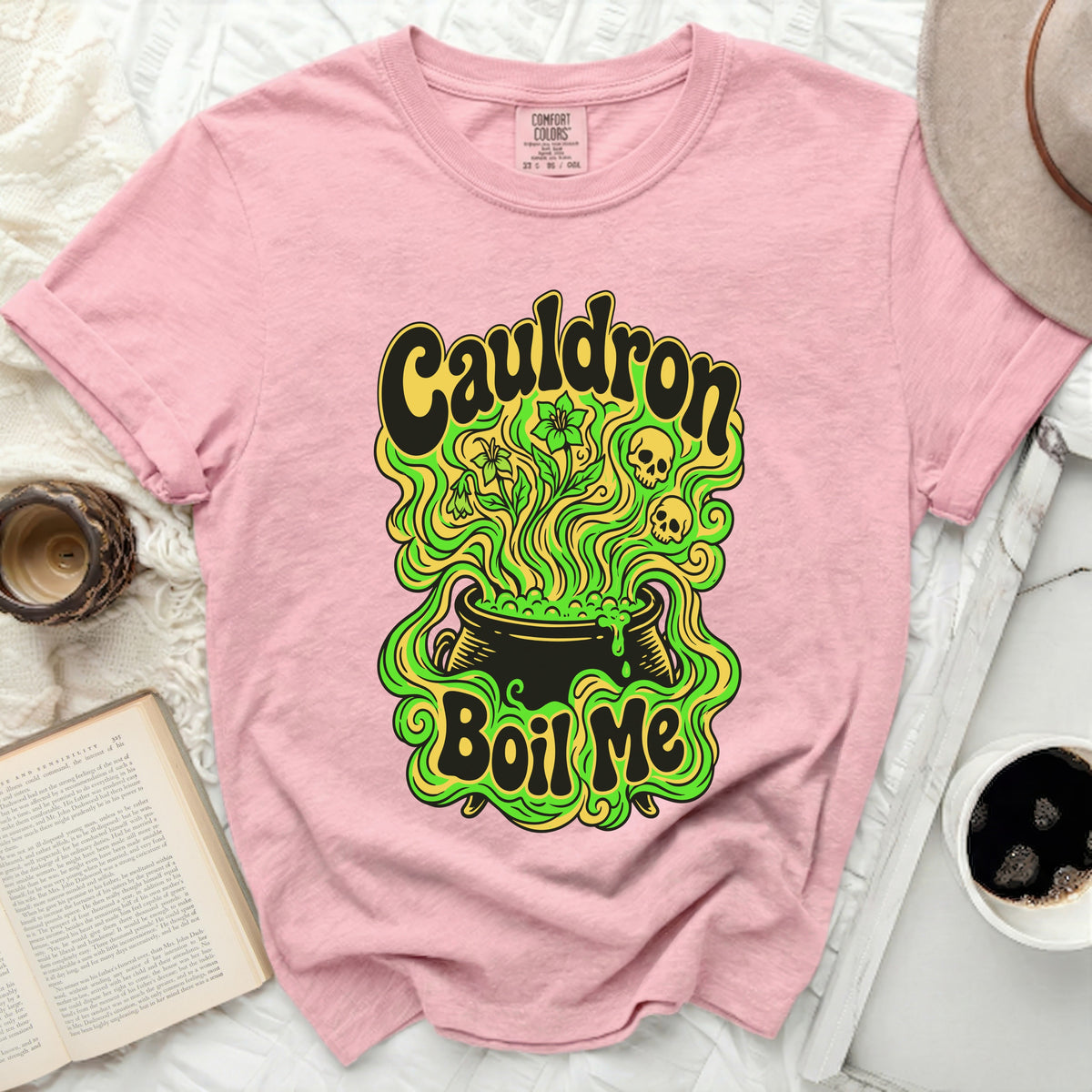 Pink t-shirt with "Cauldron Boil Me" graphic featuring a cauldron, skulls, and flowers.