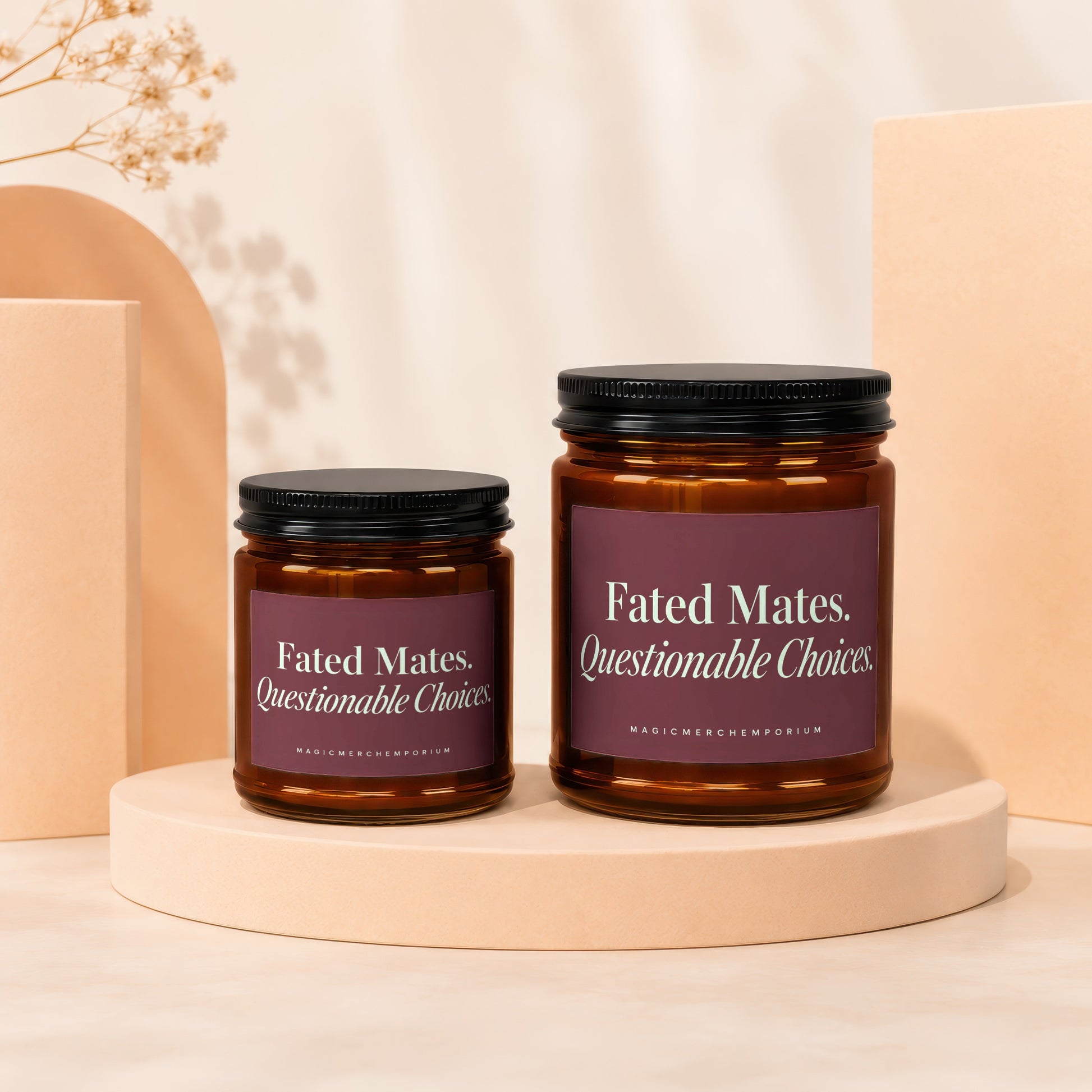 Two amber glass candles with dark lids and maroon labels that read "Fated Mates, Questionable Choices."