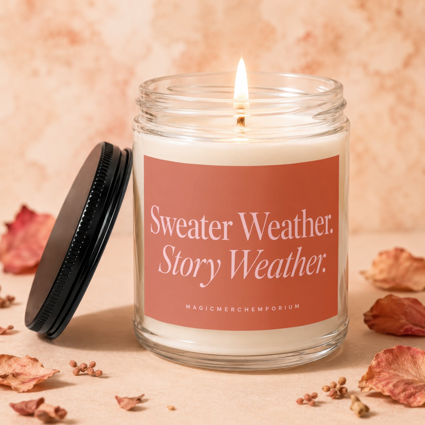 Candle in a glass jar with a black lid, reading "Sweater Weather. Story Weather."