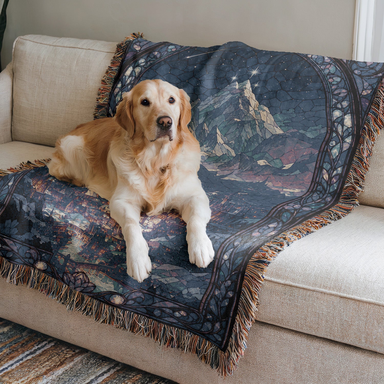 A golden retriever dog is lying on a blue and black patterned blanket on a beige couch.